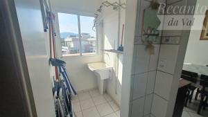 a small bathroom with a toilet and a window at Recanto Da Val in São Francisco do Sul