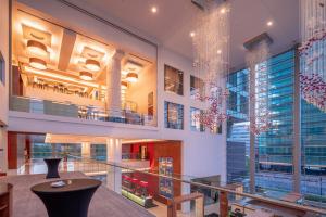 een lobby van een gebouw met grote ramen en een tafel bij Hilton Warsaw City Hotel in Warschau