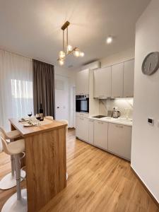 a kitchen with white cabinets and a wooden counter top at DMM Apartments in Tivat