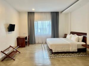 a hotel room with a bed and a window at DACO Hotel in Siem Reap