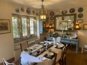 a dining room with a table with chairs and a mirror at Sycamore cottage in Matlock