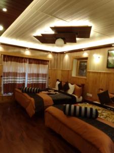 a hotel room with two beds and a couch at Himawari Hills in Nuwara Eliya