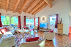 sala de estar con sofá y TV en Apartment Golfski - by Alpen Apartments, en Zell am See