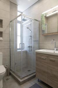 a bathroom with a glass shower and a sink at Zoe's Villa - Modern Karystos Apartments By The Port & Beach in Karistos