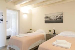 two beds in a room with white walls at Zoe's Villa - Modern Karystos Apartments By The Port & Beach in Karistos