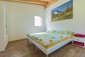 una camera da letto con un letto e un dipinto sul muro di Pauraria Puntetta a Müstair