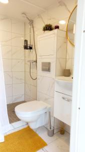 a white bathroom with a toilet and a sink at Tiny House, Kesk Loft in Tartu