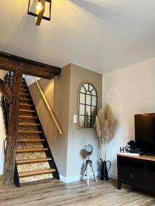 a living room with a staircase and a television at Le Duplex in Auxerre