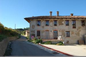 ein großes weißes Haus mit einer Straße davor in der Unterkunft Agriturismo 'd Rainè in Montelupo Albese