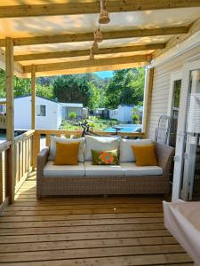 un patio con sofá en una terraza en mobil-home neuf 4-6 places camping Siblu les viviers en Lège-Cap-Ferret