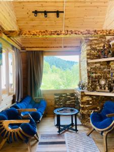 a living room with blue couches and a large window at House in The Mountains in Khulo