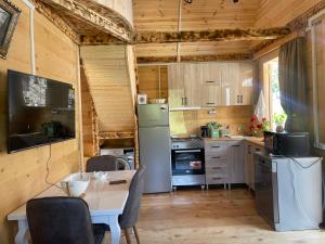 a kitchen with a refrigerator and a table with chairs at House in The Mountains in Khulo
