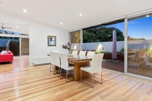 een eetkamer met een houten tafel en witte stoelen bij Saltwater in Blairgowrie