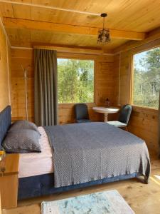 Khulo的住宿－House in The Mountains，一间卧室配有一张床、一张桌子和两把椅子