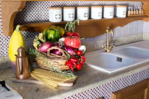 un panier de légumes sur un comptoir à côté d'un évier dans l'établissement I Giardini di Sorrento, à Sorrente