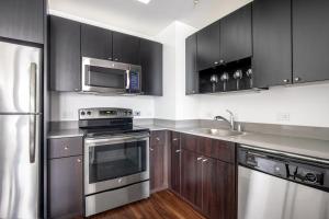 a kitchen with stainless steel appliances and wooden cabinets at SoMa 2BR w Gym Roofdeck nr Pinterest SFO-332 in San Francisco
