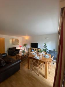 uma sala de estar com uma mesa e um sofá em The Wimbledon Apartment em Raynes Park
