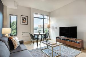 a living room with a couch and a tv and a table at Hayes Valley Studio w Rooftop WD 1 min to BART SFO-108 in San Francisco