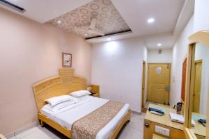 a bedroom with a bed and a bathroom at Hotel Annapoorna Residency in Hyderabad