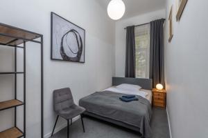 um quarto com uma cama, uma cadeira e uma janela em Centrally located 3BD home near National Museum em Praga