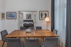 uma sala de jantar com uma mesa de madeira e cadeiras em Centrally located 3BD home near National Museum em Praga