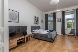 a bedroom with a bed and a desk and a television at Centrally located 3BD home near National Museum in Prague