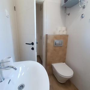 a bathroom with a white sink and a toilet at Villa Fragola 3 in Doli