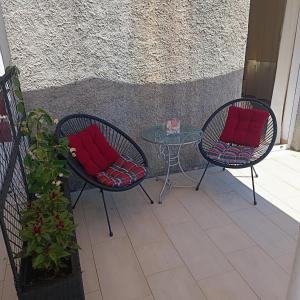 two chairs and a table with red pillows on a patio at Villa Fragola 3 in Doli
