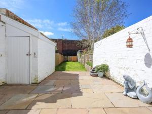 a courtyard with a white brick wall and a driveway at Comfortable Bristol Escape near Gloucester Road in Bristol