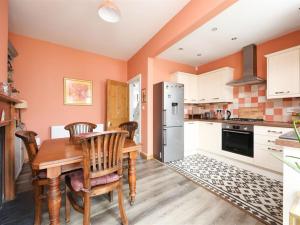 a kitchen with a table and chairs and a refrigerator at Comfortable Bristol Escape near Gloucester Road in Bristol