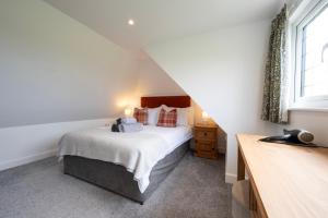 een slaapkamer met een bed en een raam bij Owlet Lodge in Chislet