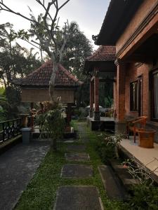 a garden outside a house with a tree at Villa Miracle Ubud in Ubud