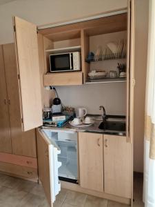 una pequeña cocina con fregadero y microondas en Baida Santos, en Santa Maria la Palma