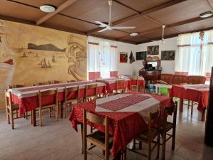 uma sala de jantar com mesas e cadeiras e um mural em Baida Santos em Santa Maria la Palma