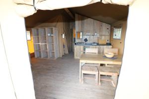 a kitchen and dining room with a table in a tent at De Zuidvliet Glamping Deluxe 2 in Wolphaartsdijk