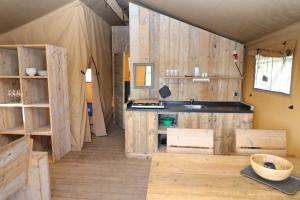 a kitchen with wooden walls and a sink in a room at De Zuidvliet Glamping Deluxe 2 in Wolphaartsdijk