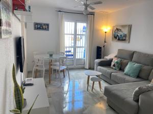 a living room with a couch and a table at Casitasmanoli Conil plaza Huerta de enmedio in Conil de la Frontera