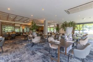 沃爾夫黑澤的住宿－Fletcher Hotel-Restaurant De Buunderkamp，餐厅设有桌椅和窗户。