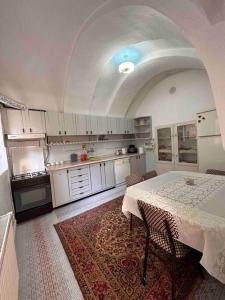 a kitchen with a table and a kitchen with white cabinets at Ayten Hanım Konağı in Ürgüp