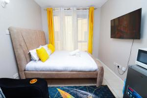 - une chambre avec un lit et une fenêtre avec des rideaux jaunes dans l'établissement Jay Authentic Homes, à Nairobi