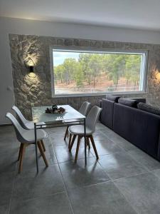 a dining room with a table and chairs and a window at Serenity - Brand new apartment in Ermioni Village in Ermioni