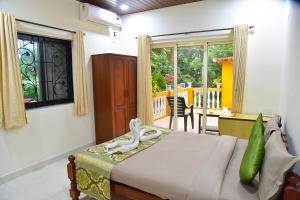 a bedroom with a bed and a table and a window at ULTIMATE STAY in Calangute