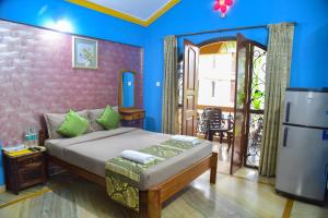 a bedroom with a bed and a refrigerator in it at ULTIMATE STAY in Calangute