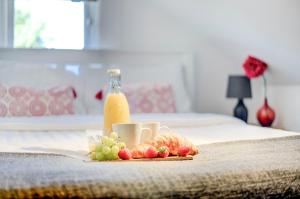 bandeja de fruta y botella de zumo de naranja en la cama en Camden and Kings Cross 3 bedroom flat - sleeps 8, en Londres