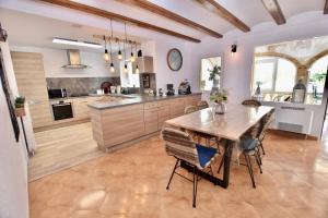 a large kitchen with a wooden table and chairs at Villa Isabel- Balcon al Mar- Javea in Jávea