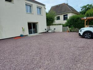 une allée avec une voiture garée devant une maison dans l'établissement Le val, à Thaon