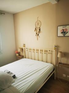 sypialnia z łóżkiem z zegarem na ścianie w obiekcie Maison au cœur de migennes w mieście Migennes