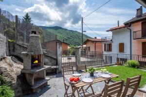 eine Terrasse mit einem Tisch und einem Steinofen in der Unterkunft Casa Elvezia - Happy Rentals in Piandera