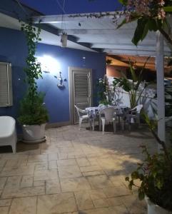 een patio met tafels en stoelen en een blauwe muur bij "Villetta tra Mare e Barocco" in Marina di Ragusa