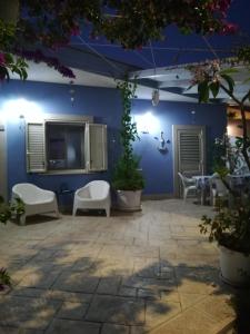 マリーナ・ディ・ラグーザにある"Villetta tra Mare e Barocco"の青い壁のパティオ(白い椅子付)